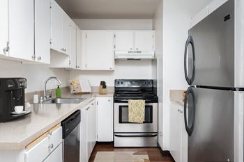 A kitchen with white cabinets and a stainless steel refrigerator.